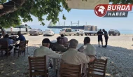 Karaya oturan gemiyi köy kahvesinden seyrediyorlar.