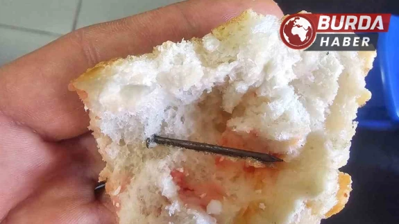 Ekmeğin içindeki çiviyi yutmak üzereyken fark etti.