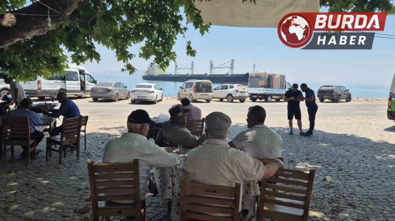 Karaya oturan gemiyi köy kahvesinden seyrediyorlar.